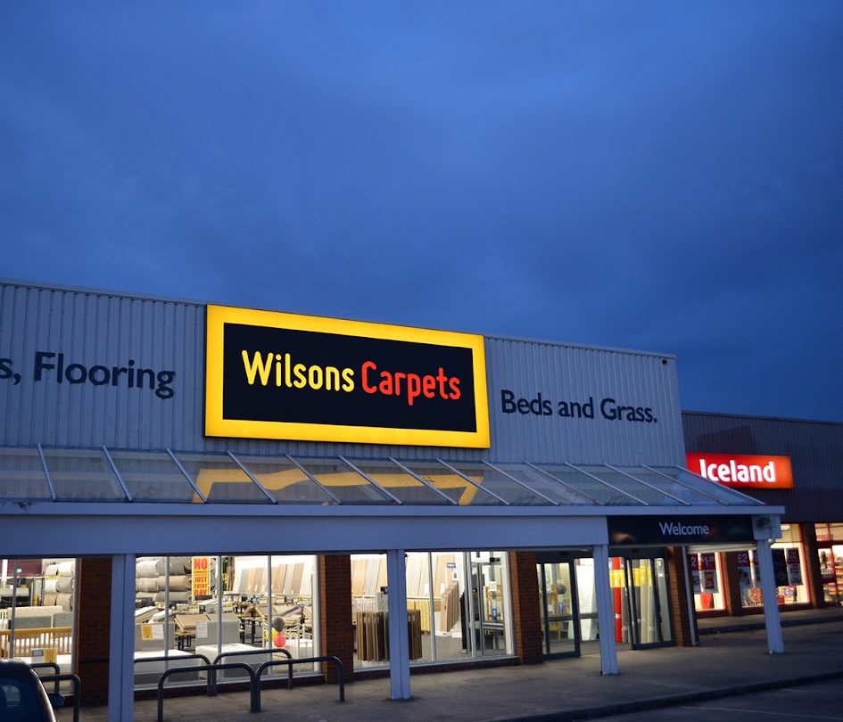 Illuminated flex face signage installed to a retail outlet.